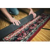 Drummer unrolling Meinl Oriental drum rug on wooden floor.