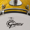 Close-up of yellow Gretsch Catalina Club drum with logo and hardware details.