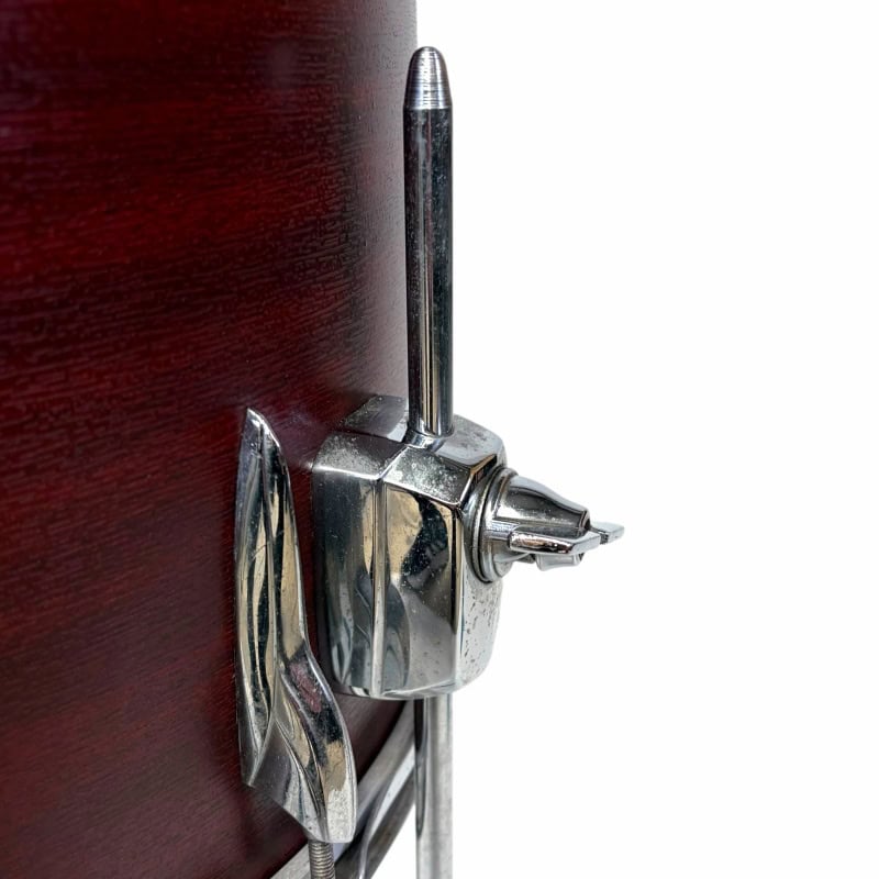 Drum hardware lock with drumstick holder, chrome finish, mounted on wooden drum kit.