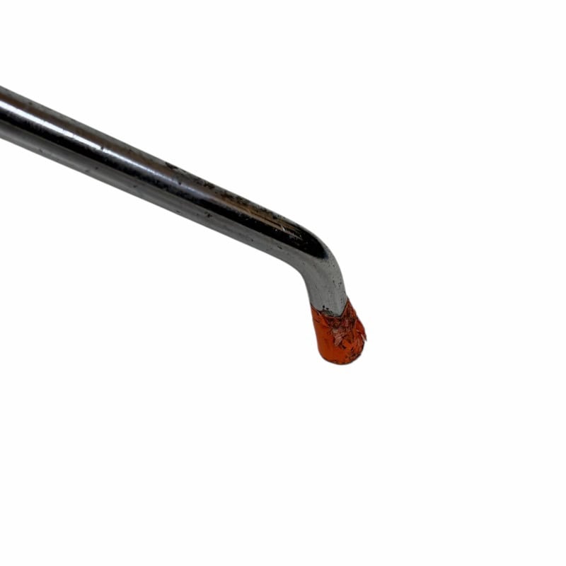 Close-up of a worn drumstick with rust and paint chipping, used for drumming.