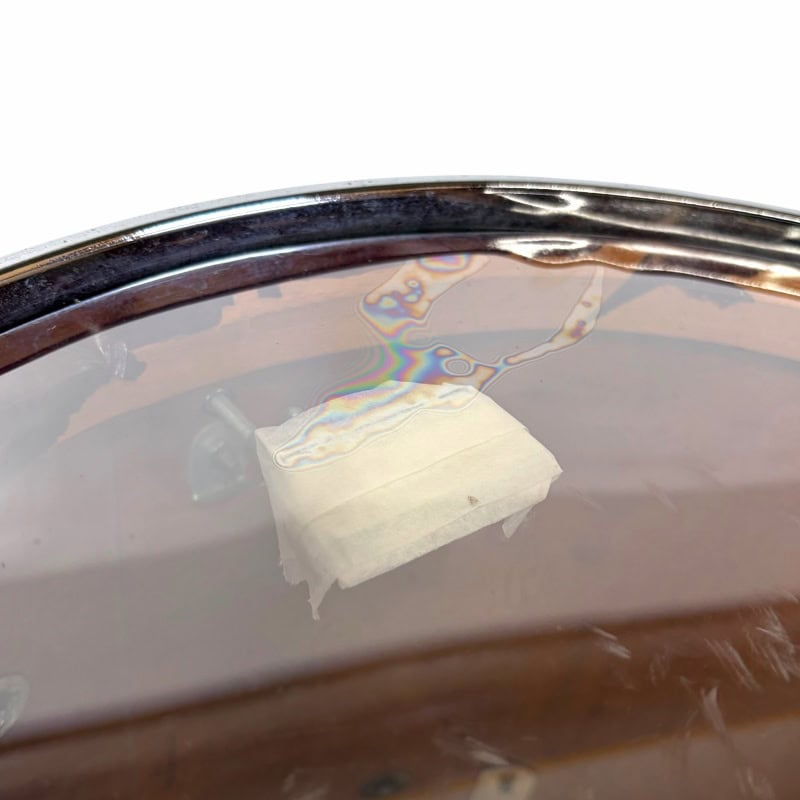 Close-up of a drum with a drumstick and tissue on the surface, highlighting percussion equipment.