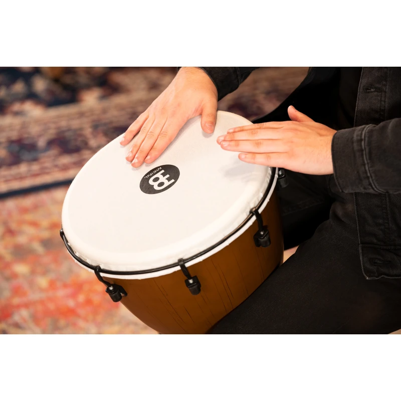 Close-up of a person playing a hand drum, focusing on hands and drum surface.