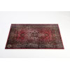 Vintage Persian rug with detailed floral and geometric designs in red and black.