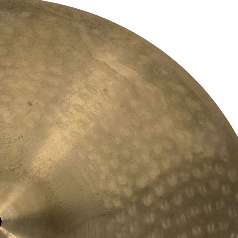 Close-up of a cymbal used in drumming, highlighting its texture and metallic finish.
