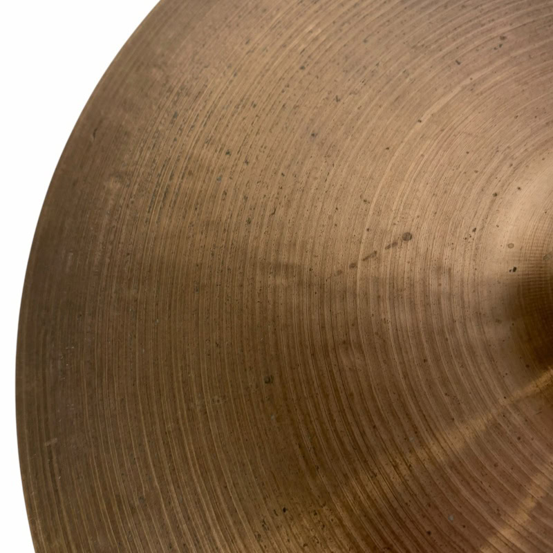 Close-up of a bronze cymbal for drumming, showing detailed surface texture.