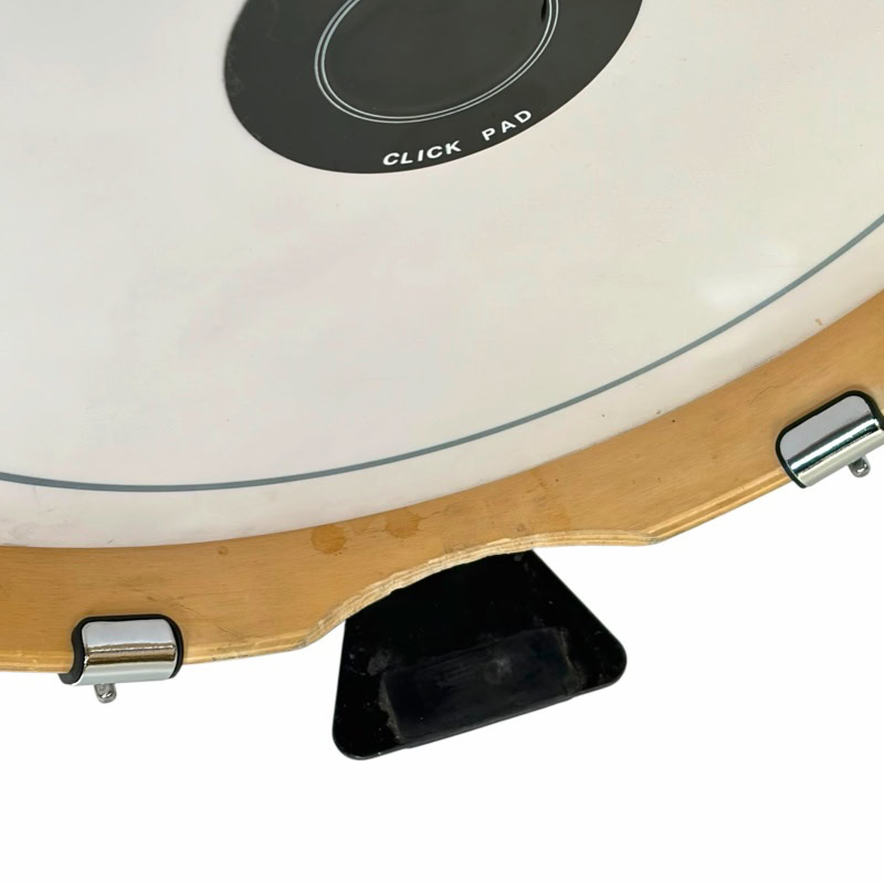 Close-up of electronic drum pad with wooden frame and foot pedal, ideal for drumming practice.