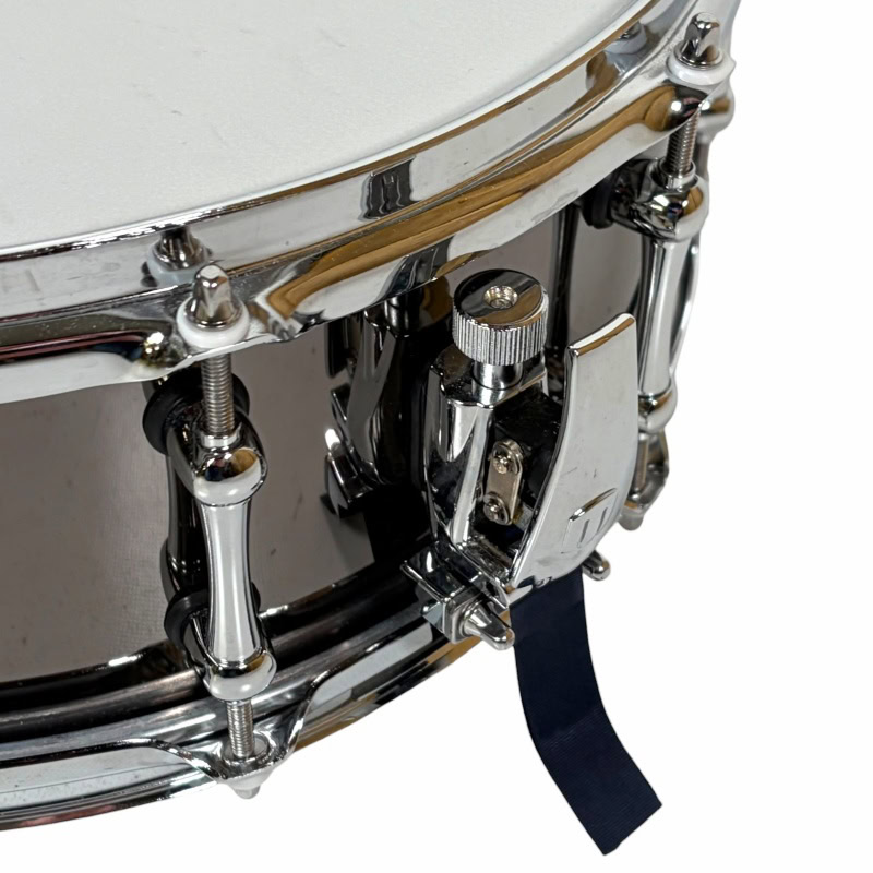 Close-up of a professional snare drum with chrome hardware and drum strap.