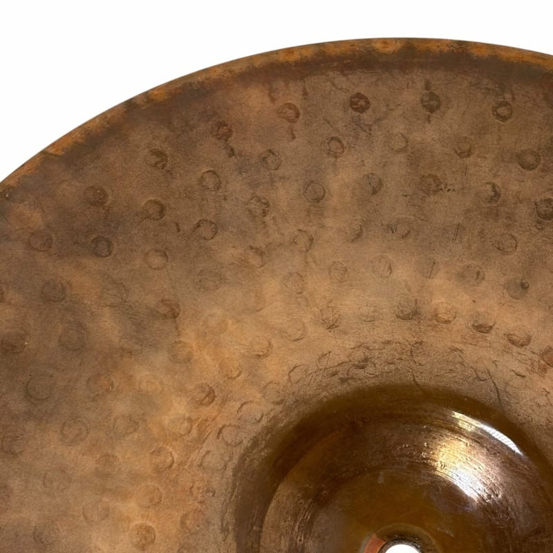 Close-up of a well-used cymbal with visible wear and patina, perfect for drumming enthusiasts.