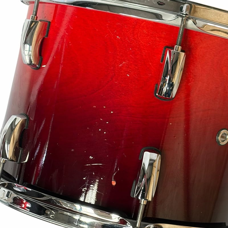Close-up of a red drum kit with chrome hardware, perfect for drummers and music enthusiasts.