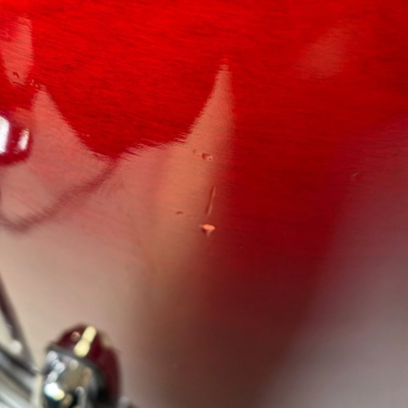 Close-up of a red drum kit with drumsticks, highlighting professional percussion equipment.