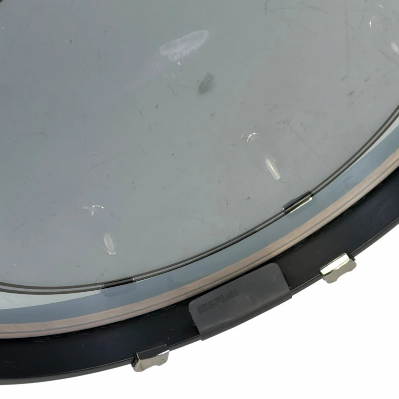 Close-up of a drum practice pad with drumsticks on a white background.