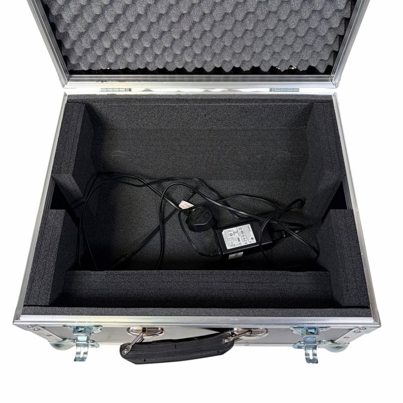 Equipment case with power adapter and cables for drumming gear.