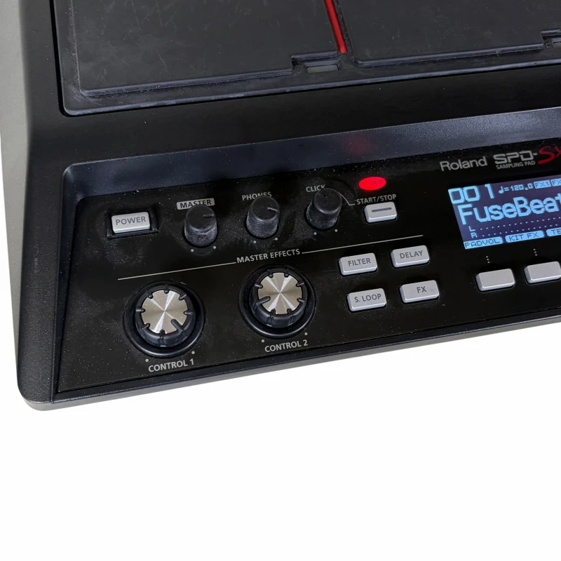 Roland electronic drum machine with control knobs and digital display.