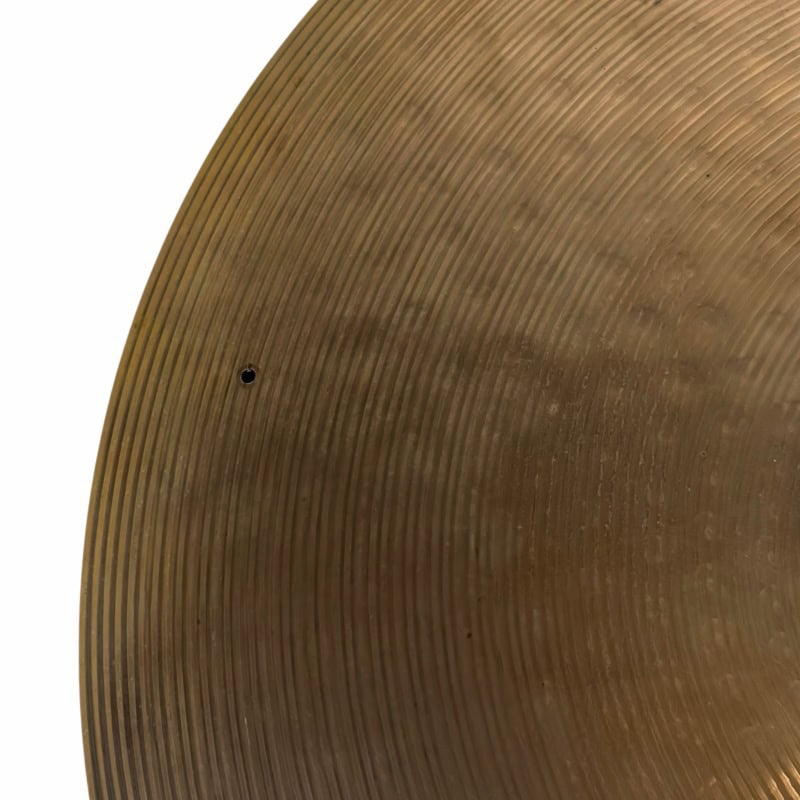 Close-up of a bronze cymbal with detailed grooves for drumming enthusiasts.