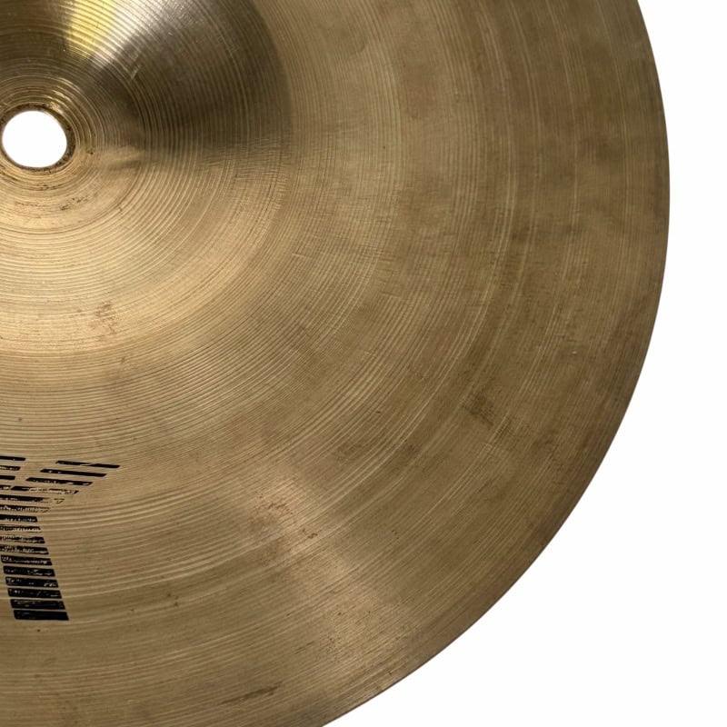 Close-up of a golden cymbal used in drum kits, highlighting its texture and craftsmanship.
