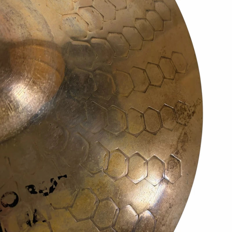 Close-up of a handcrafted cymbal with hexagonal pattern and patina, showcasing high-quality percussi.