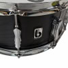 Black snare drum with chrome tension rods and badge, close-up shot highlighting drum details.
