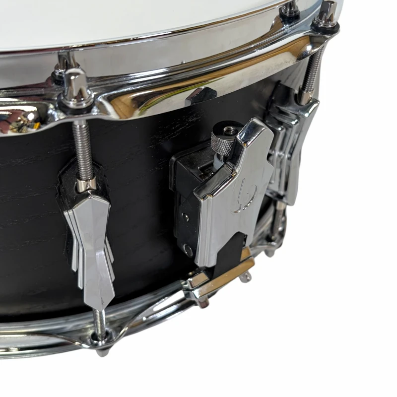 Close-up of a snare drum with drum latch and hardware details.