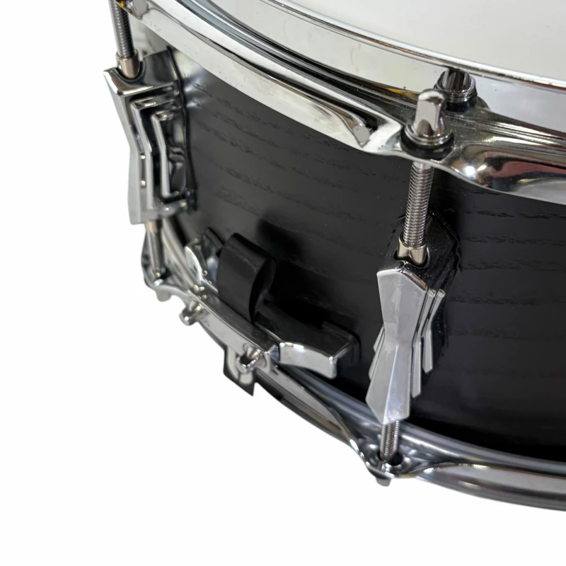Close-up of a black drum with chrome hardware, showcasing detailed drum lugs and tension rods.