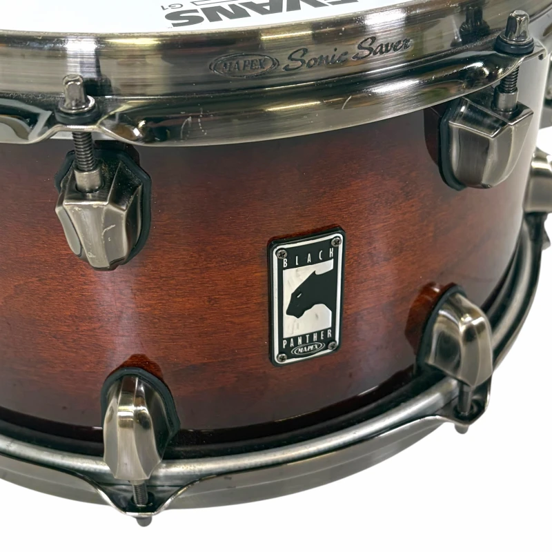 Close-up of a wooden drum with Black Panther logo and hardware details.