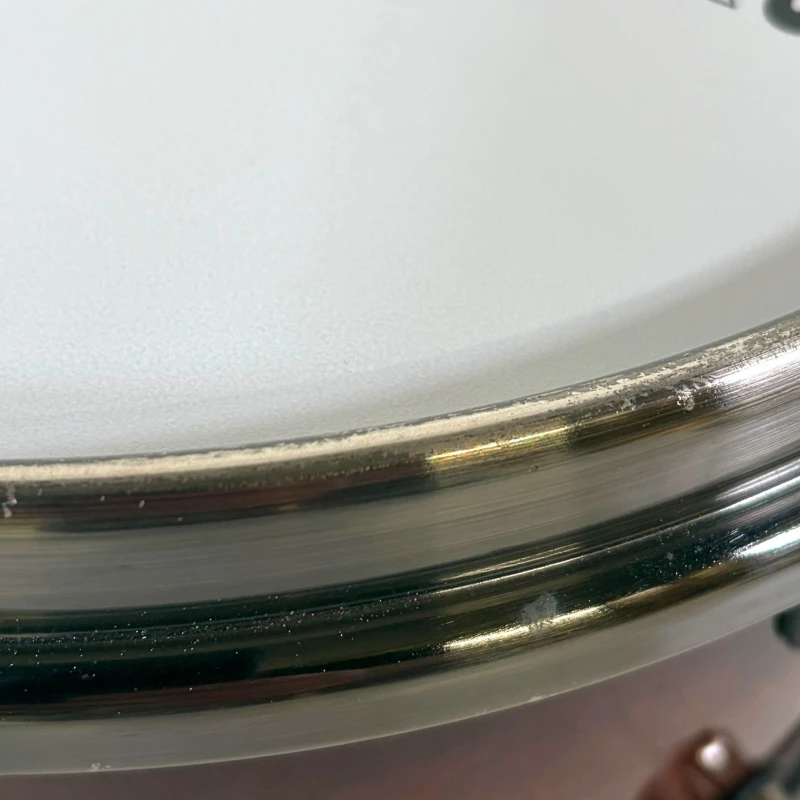 Close-up of a drum kit with metallic hardware and white drum shell, perfect for drumming enthusiasts.