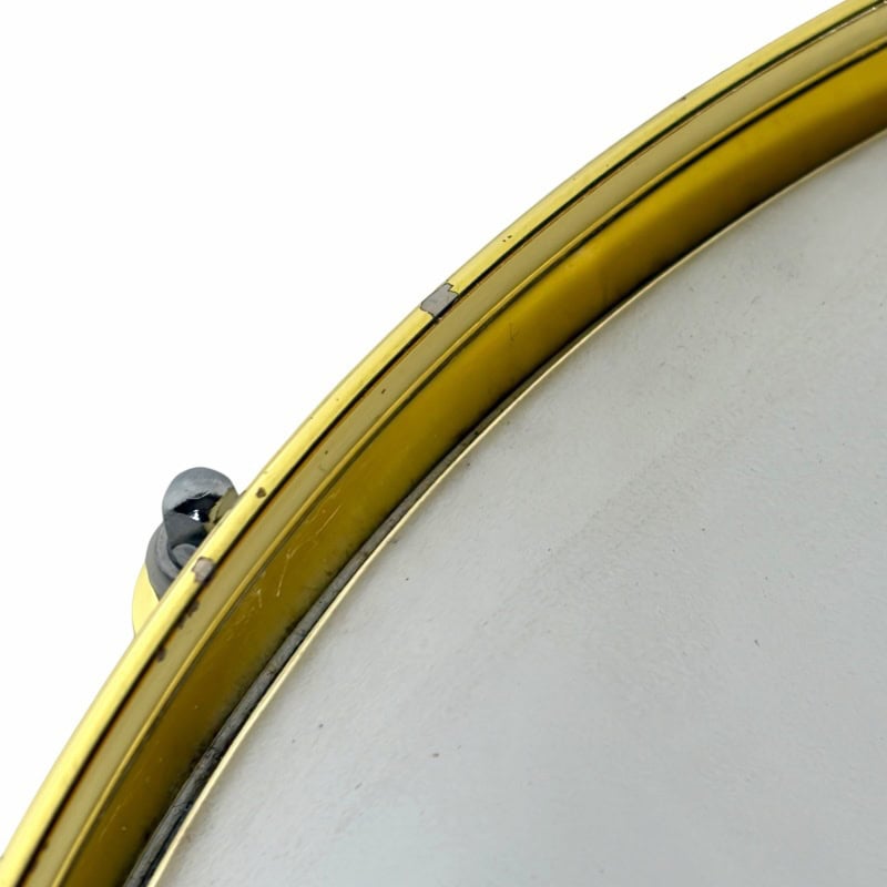 Close-up of a drum snare with gold hardware, highlighting the drum's detailed craftsmanship.