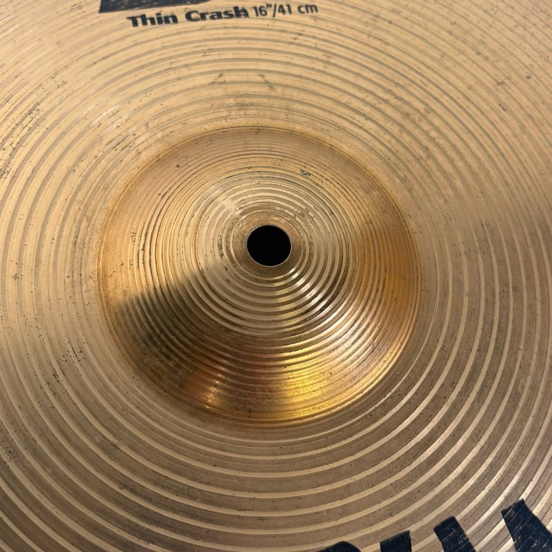 Crash cymbal for drummers, showing detailed concentric grooves and central hole.