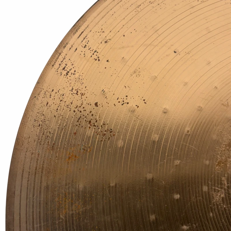 Vintage cymbal with visible wear and patina, highlighting its textured surface and musical history.