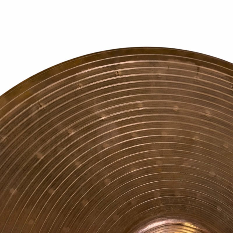Close-up of a cymbal used in drumming, highlighting the metal surface and grooves.