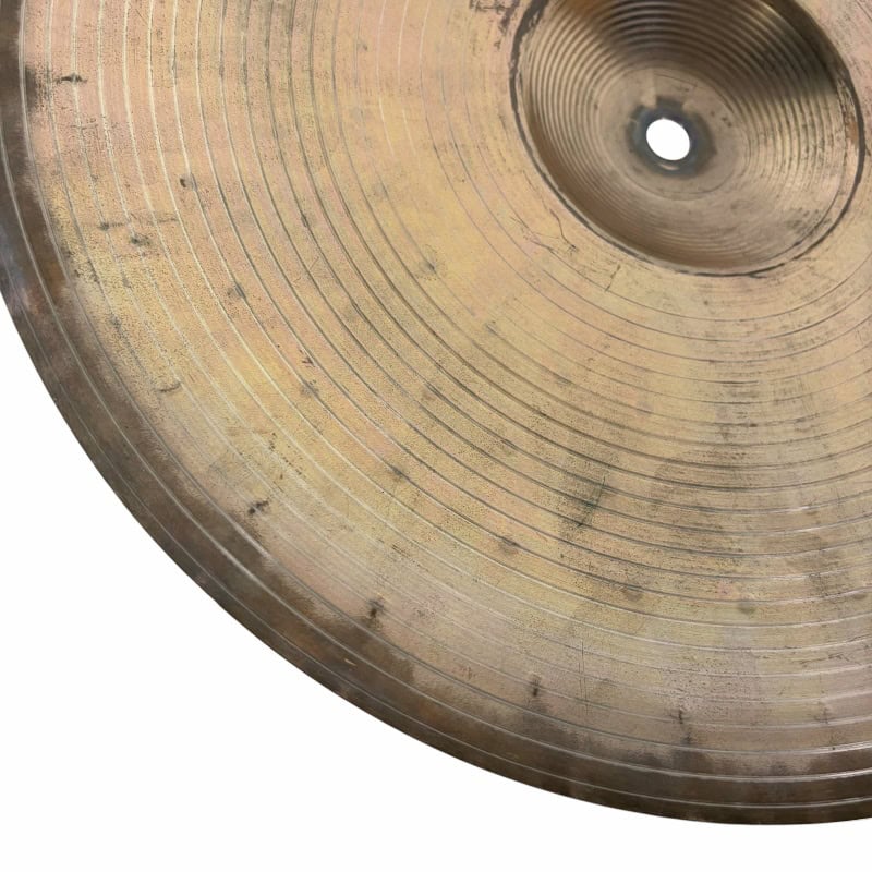 Close-up of a vintage cymbal used in drumming and percussion.