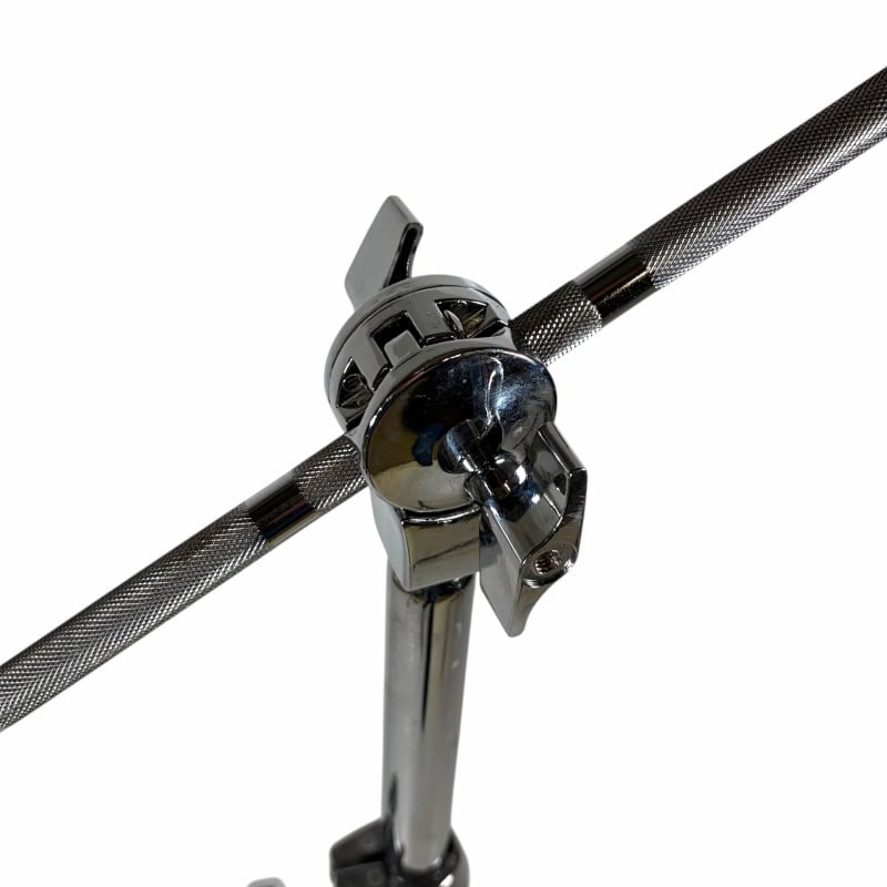Close-up of drum hardware clamp securing a drumstick holder on a metal stand.
