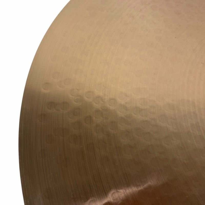 Close-up of a cymbal showing detailed hammer marks and metallic texture.
