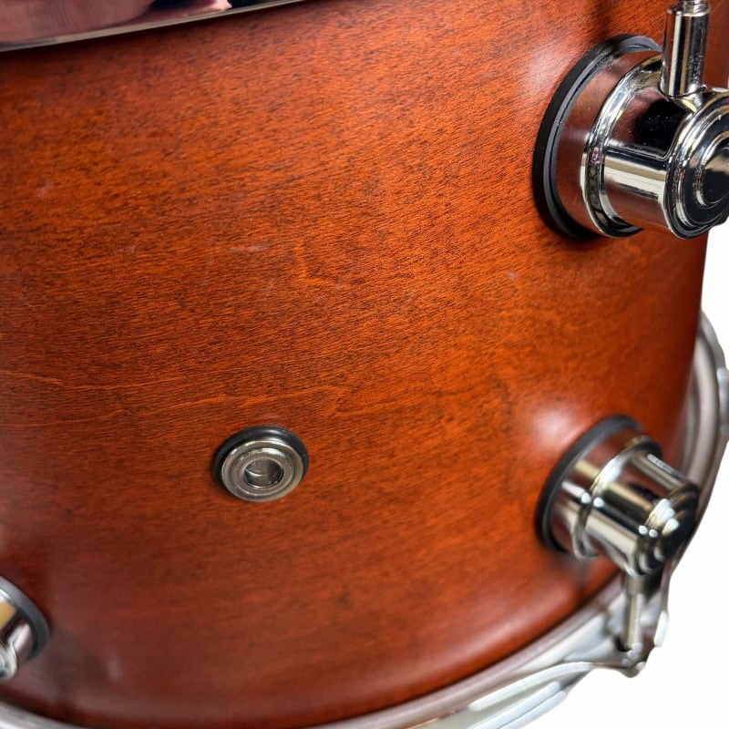 Close-up of a wooden snare drum with chrome hardware.
