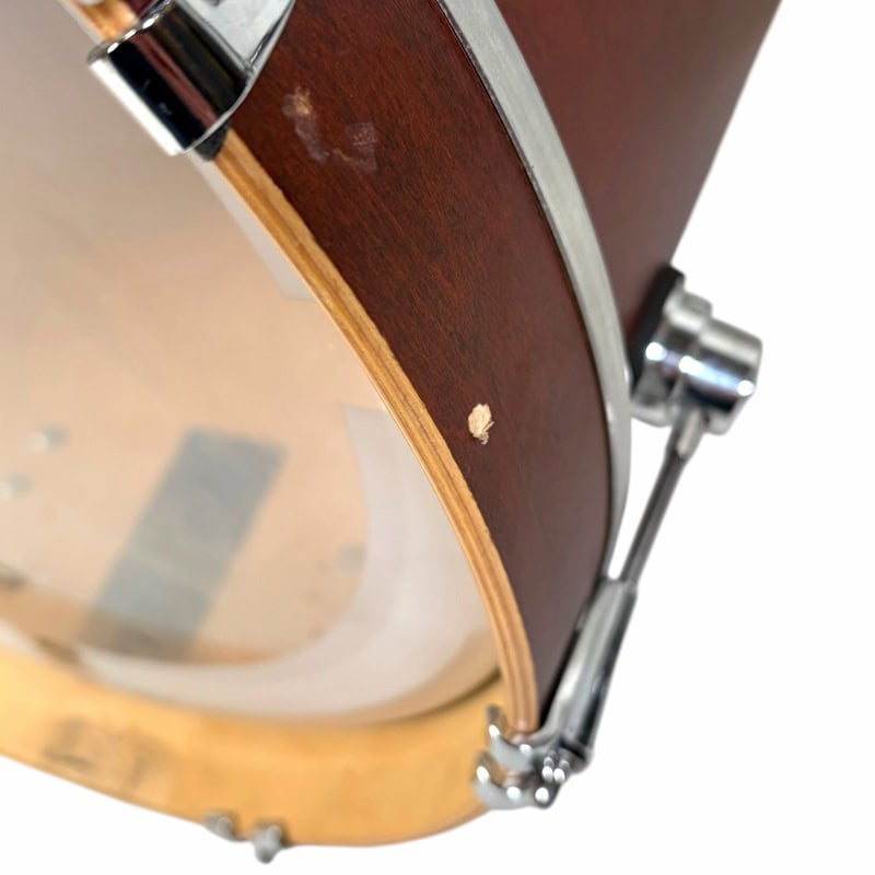 Close-up of a wooden acoustic drum with metal hardware, showcasing craftsmanship and quality.