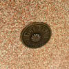 Close-up of Gretsch drum badge on a textured drum shell surface.