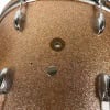 Close-up of a glittery, textured drum shell with hardware.