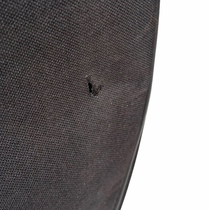 Close-up of a damaged speaker grille at Drummers Only music store.