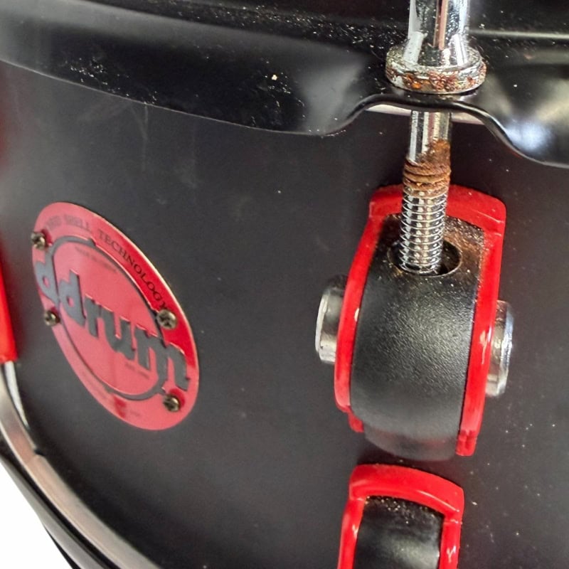 Close-up of drum hardware with red and black components at Drummers Only.