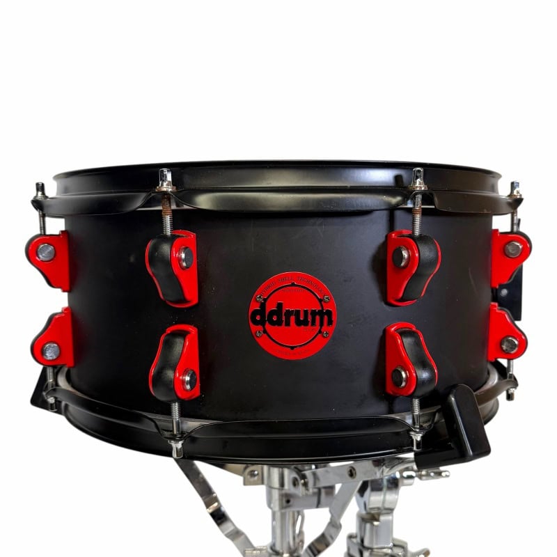 Snare drum with black finish and red hardware, perfect for drumming enthusiasts.