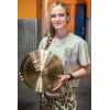Female drummer holding a cymbal at Drummers Only studio.