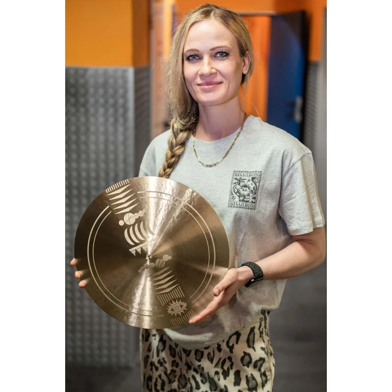 Female drummer holding a cymbal at Drummers Only studio.
