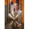 Female drummer holding a large cymbal in a music studio corridor.
