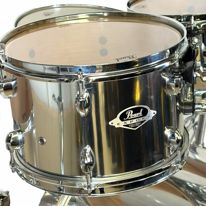 Close-up of a shiny Pearl export drum with detailed hardware and drumhead.
