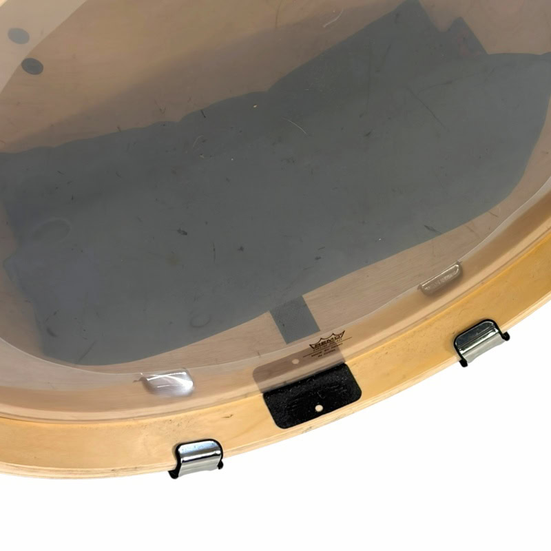 Close-up of a drum practice pad with drumsticks and a transparent surface.