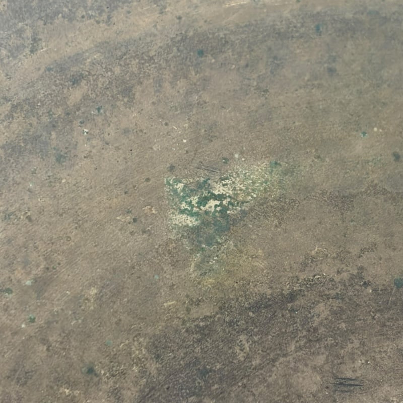 Close-up of a cymbal surface with patina and wear marks.