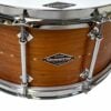 Close-up of a wooden snare drum with chrome hardware and brand logo.