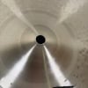 Close-up of a dark crash cymbal with concentric circles and central hole.