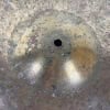 Close-up of a vintage cymbal with patina and a central hole for mounting.