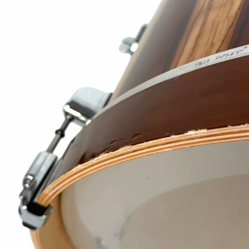 Close-up of a drum kit with wooden shells and hardware.
