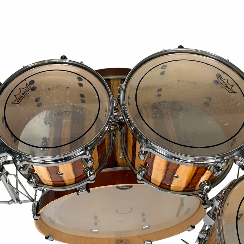 High-quality wooden drum kit with clear drumheads and chrome hardware.